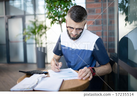 Young businessman analyzing finances and expenses 57235514