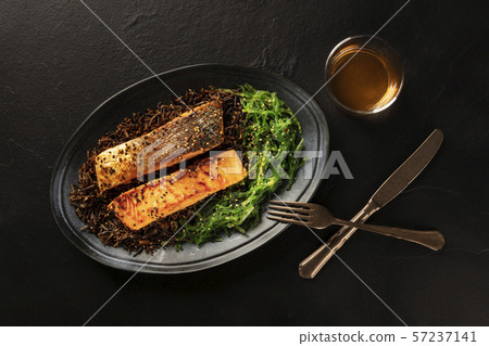 Salmon with sesame seeds, wakame seaweed and wild rice, shot from the top with a glass of white wine 57237141