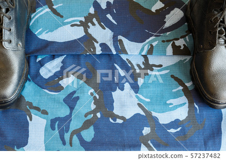 A pair of black army boots on fabric with blue 57237482