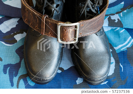 Army boots and army belt on blue camouflage Army boots and army belt on blue camouflage 57237536