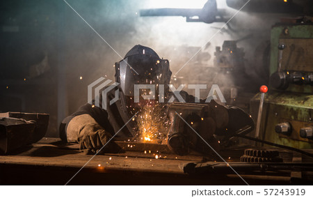Welder is welding metal part in factory Welder is welding metal part in factory 57243919