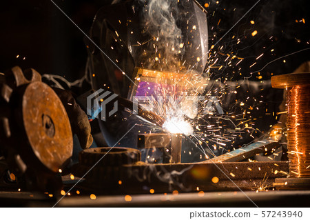 Welder is welding metal part in factory Welder is welding metal part in factory 57243940