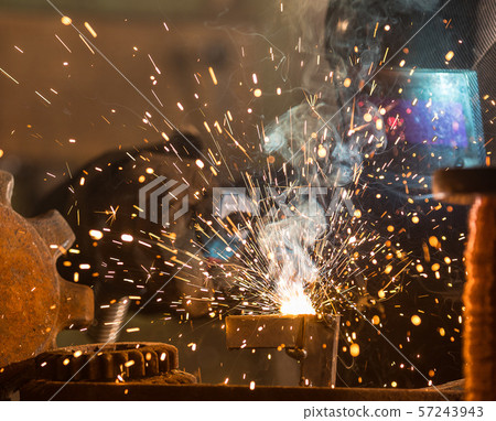 Welder is welding metal part in factory Welder is welding metal part in factory 57243943