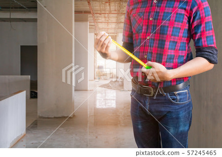 hand of engineer is holding tape measure 57245465