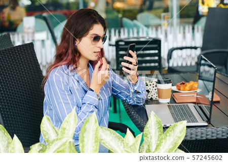 Woman applying liquid lipstick 57245602