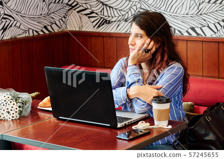 Pensive woman looking through cafe window 57245655