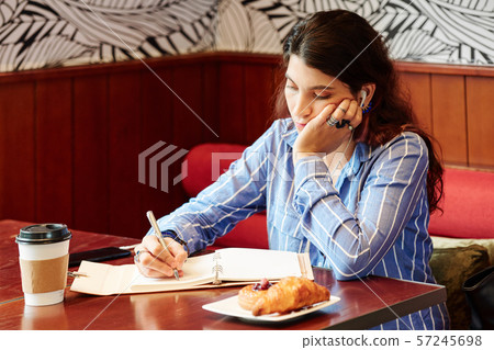 Woman listening to lection and taking notes Woman listening to lection and taking notes 57245698