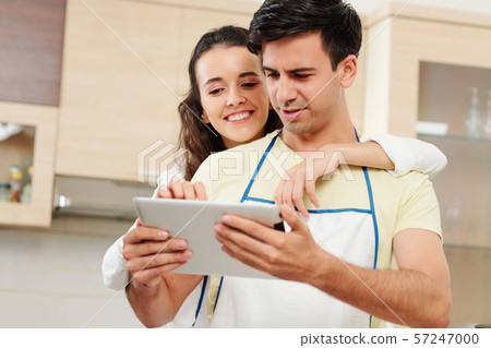 Couple reading recipe on tablet computer Couple reading recipe on tablet computer 57247000