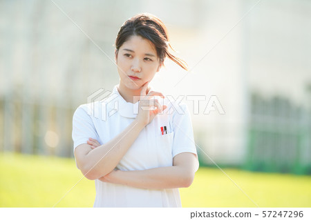 A woman in a white coat posing with doubts A woman in a white coat posing with doubts 57247296
