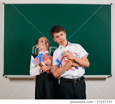 Portrait of a schoolboy and schoolgirl posing with 57247355