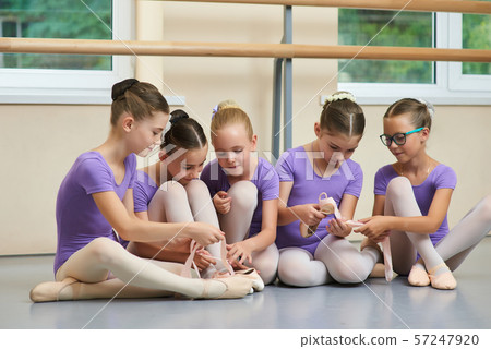 Cute little ballet dancers sitting on floor. 57247920