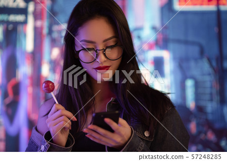 Woman Using a Smartphone in the City at Night 57248285
