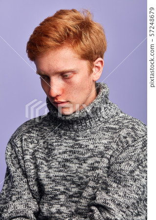 sad unhappy depressed young man in fashion sweater looking down 57248679