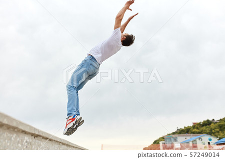 Young man doing back flip in the street. Sport Activities outdoors. 57249014