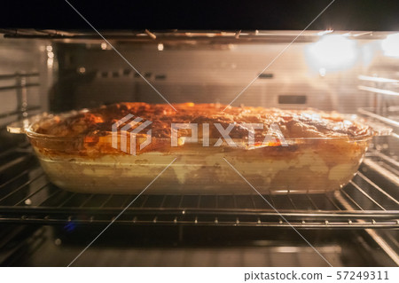 Baked meat with potatoes and cheese in the oven 57249311