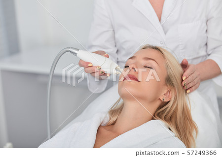 pleasant woman with closed eyes receiving beauty treatment 57249366