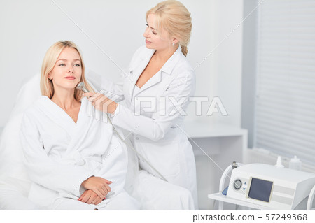 lady in sitting and professional cosmetologist cleaning with dermabrasion tool lady in sitting and professional cosmetologist cleaning with dermabrasion tool 57249368