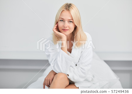 beautiful blonde woman touching her cheeck with a palm and poing to the cameral 57249436