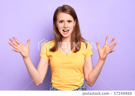 Irritated young female keeps hands wide apart, gestures emotionally, shouts 57249988