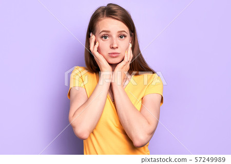 Amazed thoughtful girl holds face with hands, wonders sudden news Amazed thoughtful girl holds face with hands, wonders sudden news 57249989