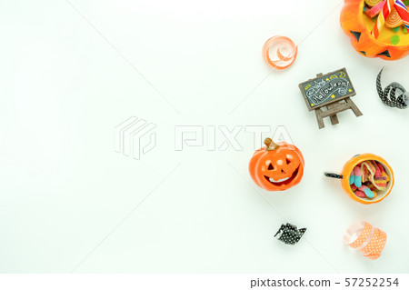 Table top view aerial image of decoration Happy Halloween day background concept.Flat lay accessories essential object to party the pumpkin & doll and candy on white wooden.Space for creative design. 57252254