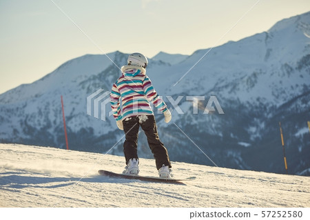 Female snowboarder in sun flare Female snowboarder in sun flare 57252580
