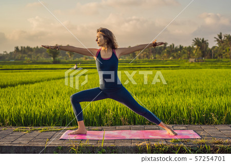 Young woman practice yoga outdoor in rice fields in the morning during wellness retreat in Bali 57254701