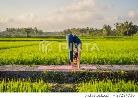 Young woman practice yoga outdoor in rice fields in the morning during wellness retreat in Bali 57254730