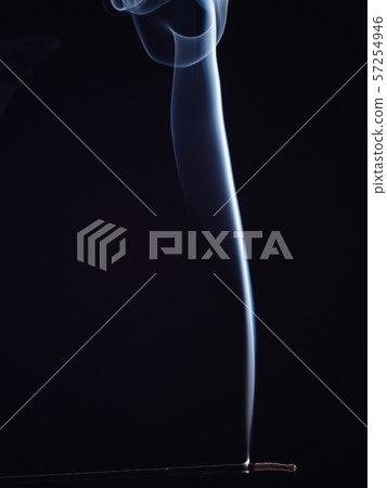 Burning incense smouldering with white smoke Burning incense smouldering with white smoke 57254946