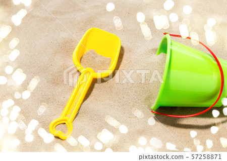 close up of toy bucket and shovel on beach sand 57258871