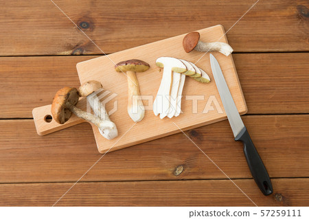 edible mushrooms, kitchen knife and cutting board 57259111