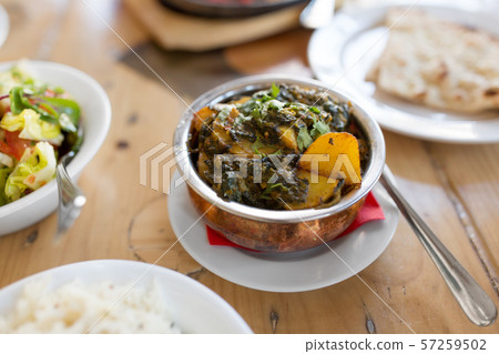 close up of aloo palak dish in bowl on table 57259502