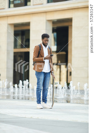 Young African Man Using Smartphone in City Young African Man Using Smartphone in City 57263147