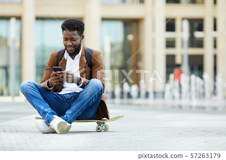 Young African-American Man Texting in City Square 57263179