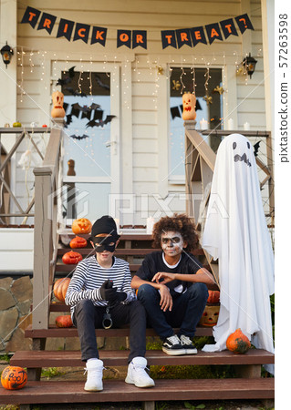 Two Boys Posing by Decorated House on Halloween 57263598