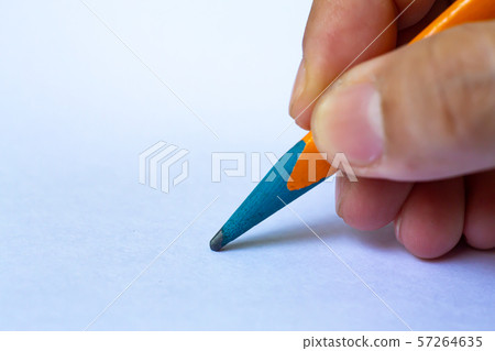 Woman's right Hand holding multicoloured pencil, writing letter on white paper texture background, Notebook, Close up & Macro shot, Selective focus, Communication, Stationery concept 57264635