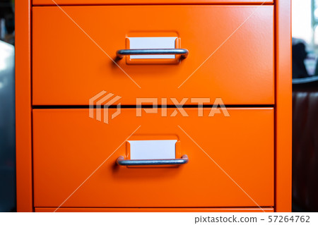 Filing cabinet with closed drawer, 2 white cards for write letter, Orange metal color, Administration and storage concept, closeup & Macro shot 57264762