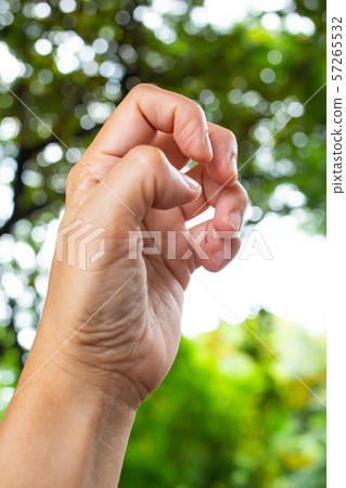 Trigger Finger lock on fingers of woman's side left hand, Suffering from pain, in bokeh green garden background, Close up & Macro shot, Office syndrome, Health care concept 57265532