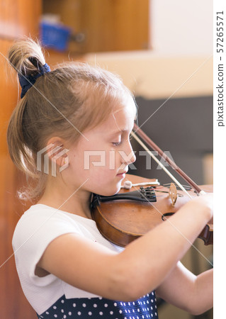 Child, little girl playing violin indoors in music class. vertical photo 57265571