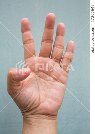 Trigger Finger lock on thumb finger of woman's front left hand, Suffering from pain, On Blue-grey colour background, Close up & Macro shot, Office syndrome, Health care concept Trigger Finger lock on thumb finger of woman's front left hand, Suffering from pain, On Blue-grey colour background, Close up & Macro shot, Office syndrome, Health care concept 57265642