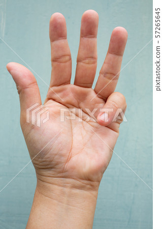 Trigger Finger lock on little finger of woman's front left hand, Suffering from pain, On Blue-grey colour background, Close up & Macro shot, Office syndrome, Health care concept Trigger Finger lock on little finger of woman's front left hand, Suffering from pain, On Blue-grey colour background, Close up & Macro shot, Office syndrome, Health care concept 57265645