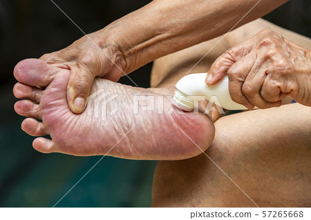 Senior woman's hands massaging her foot, Using analgesic liquid, muscle pain reliever roll on medicine, Blue swimming pool background, Asian Body skin part, About Massage, Healthcare concept 57265668