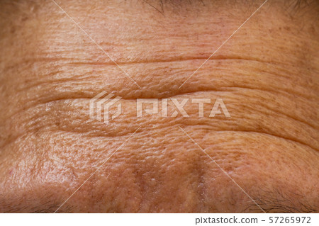 Senior woman's wrinkled forehead, Close up & Macro shot, Selective focus, Light & Shadow, Body part, Healthcare concept 57265972