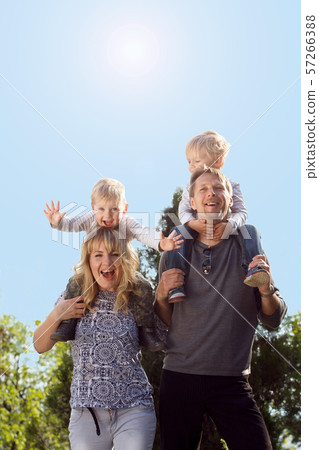 Happy kids sitting on pearents shoulder. Happy kids sitting on pearents shoulder. 57266388