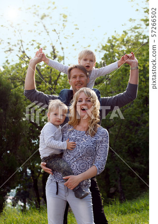 Happy kids sitting on pearents shoulder. 57266502