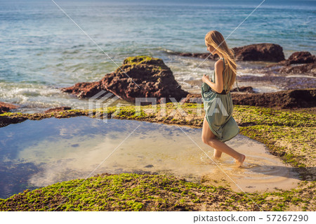 Young woman tourist on Pantai Tegal Wangi Beach, Bali Island, Indonesia. Bali Travel Concept Young woman tourist on Pantai Tegal Wangi Beach, Bali Island, Indonesia. Bali Travel Concept 57267290