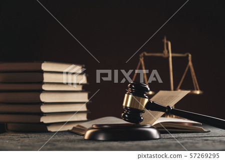 Law concept - Open law book with a wooden judges gavel on table in a courtroom or law enforcement 57269295