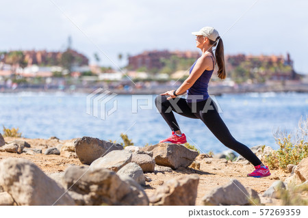 Young woman stretching legs before running workout Young woman stretching legs before running workout 57269359