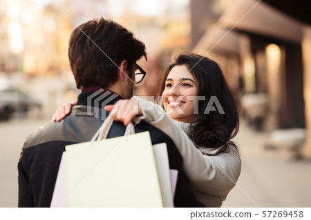 Successful shopping. Excited woman embracing husband after shopping Successful shopping. Excited woman embracing husband after shopping 57269458