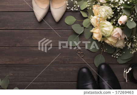 Bride groom shoes and roses bouquet on wooden floor Bride groom shoes and roses bouquet on wooden floor 57269463